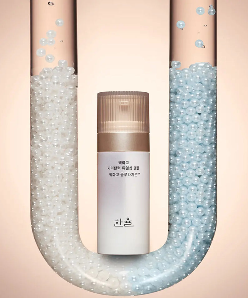Ampoule HANYUL Baekhwago Gimitanryuk Dual Shot 45ml entre deux tubes de perles blanches et bleues.