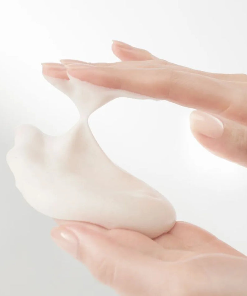 Texture crémeuse du HANYUL Extreme Cream Cleansing Foam 200ml entre les mains, illustrant sa douceur et hydratation.