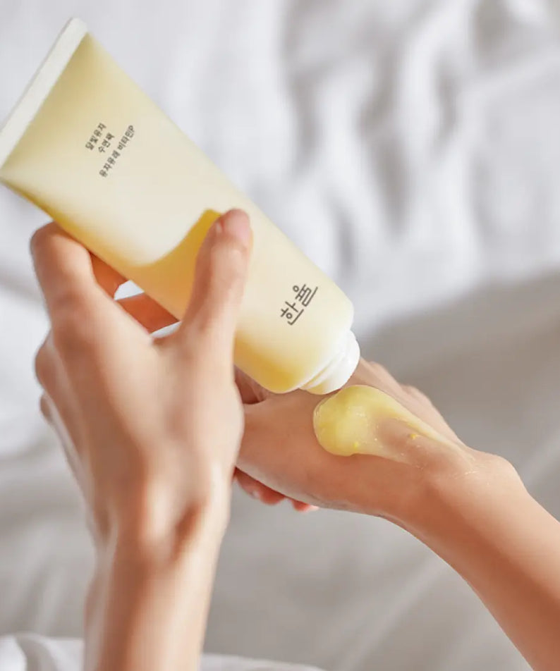 Application du HANYUL Moonlight Yuja Sleeping Pack 100ml sur la main, soin de nuit hydratant pour une peau éclatante.