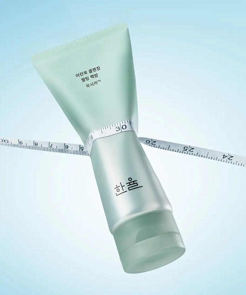 Emballage de 100g HANYUL Young Artemisia Cleansing Pack Balm sur fond bleu avec ruban à mesurer.