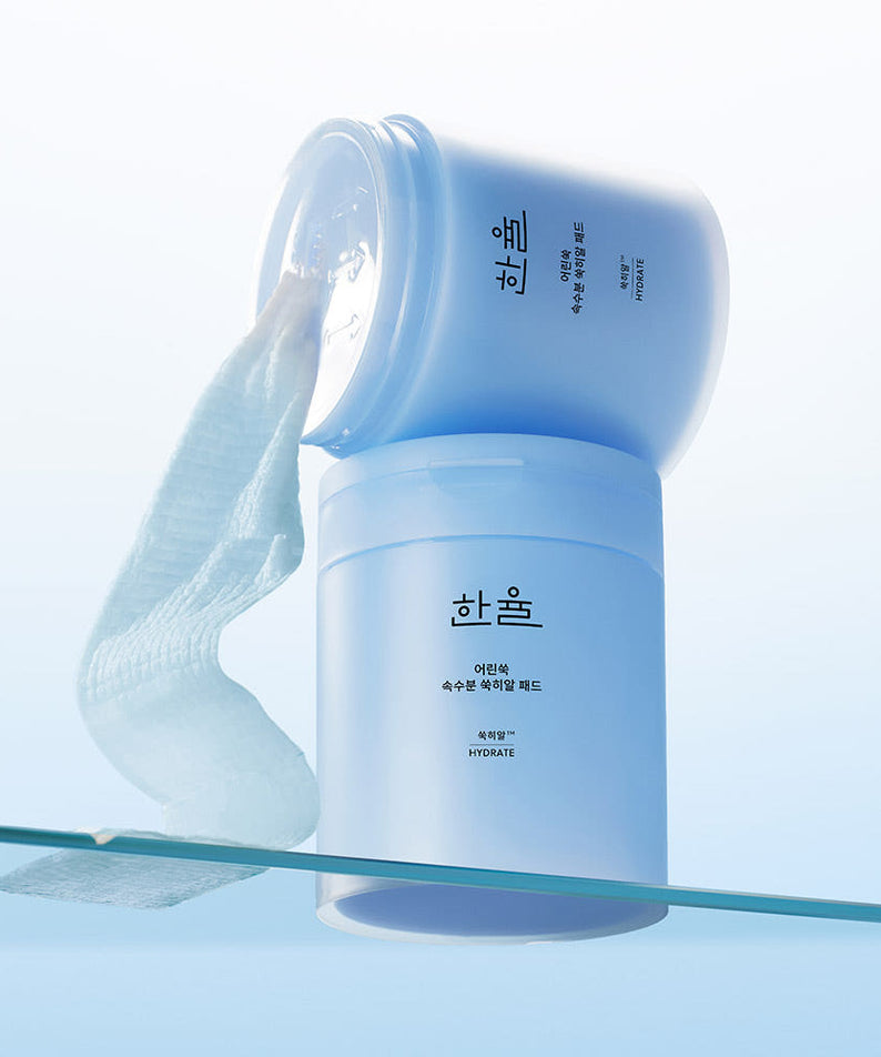 Coupelle de HANYUL Young Artemisia Extract Moisturizing Pad 60 Sheets ouverte montrant un tampon hydratant, fond bleu apaisant.