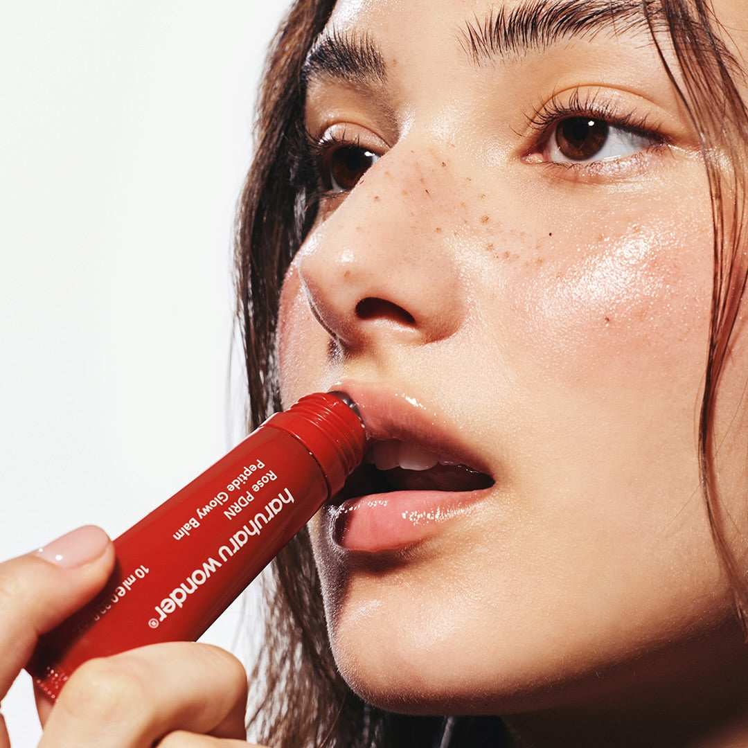 HARUHARU Rose PDRN  Peptide Glowy Balm 10ml, femme appliquant un baume rosé, emballage rouge, peau lumineuse.