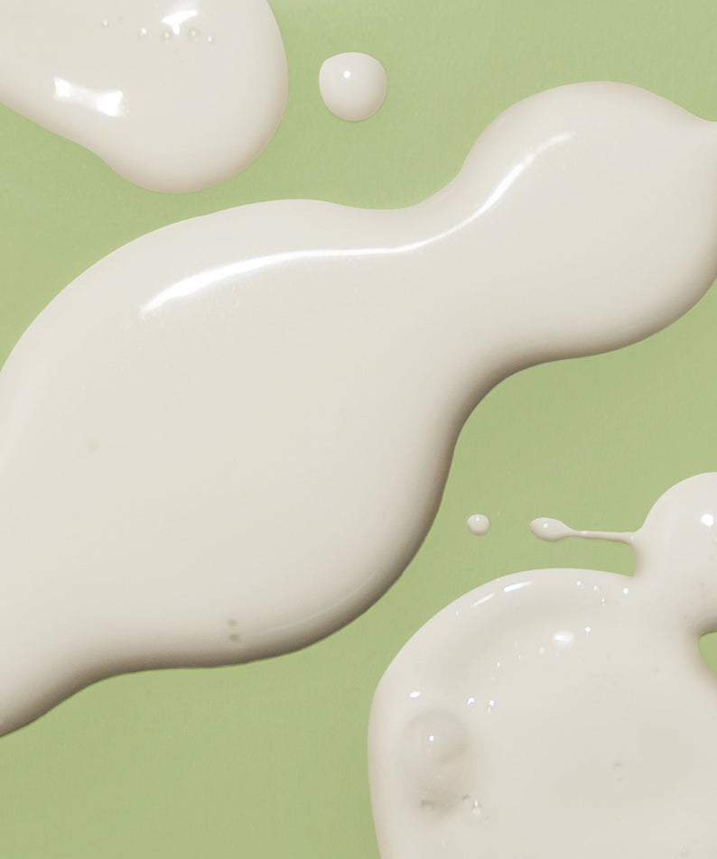 Texture de l'HARUHARU Black Bamboo Daily Smoothing Body Oil 200ml sur fond vert.