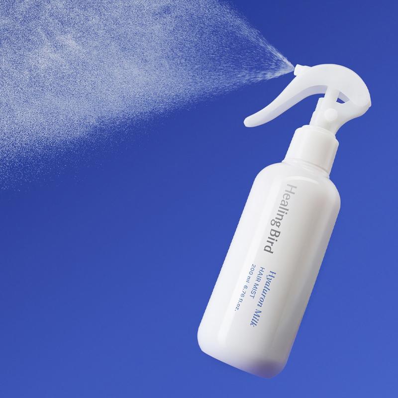 HEALING BIRD Hyalutonic Milk Hair Mist 200ml, flacon spray sur fond bleu, marque HEALING BIRD en contexte visuel beauté.