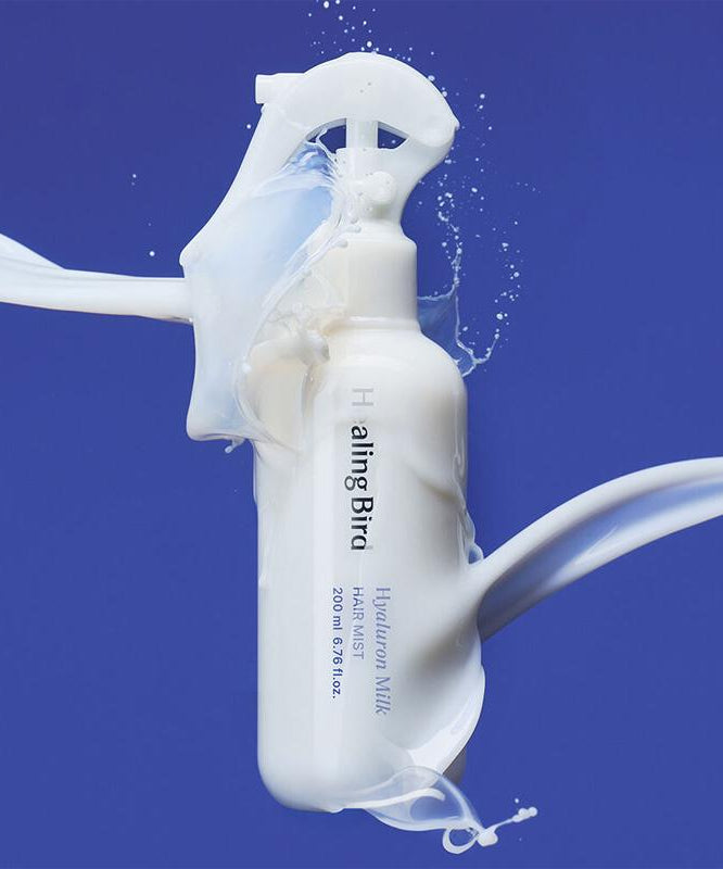HEALING BIRD Hyalutonic Milk Hair Mist 200ml sur fond bleu avec effet de laitage.