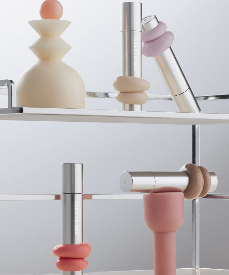 HEART PERCENT Dot On Mood One Way Glow Tint, produits cosmétiques modernes sur étagère métallique, accents pastel.