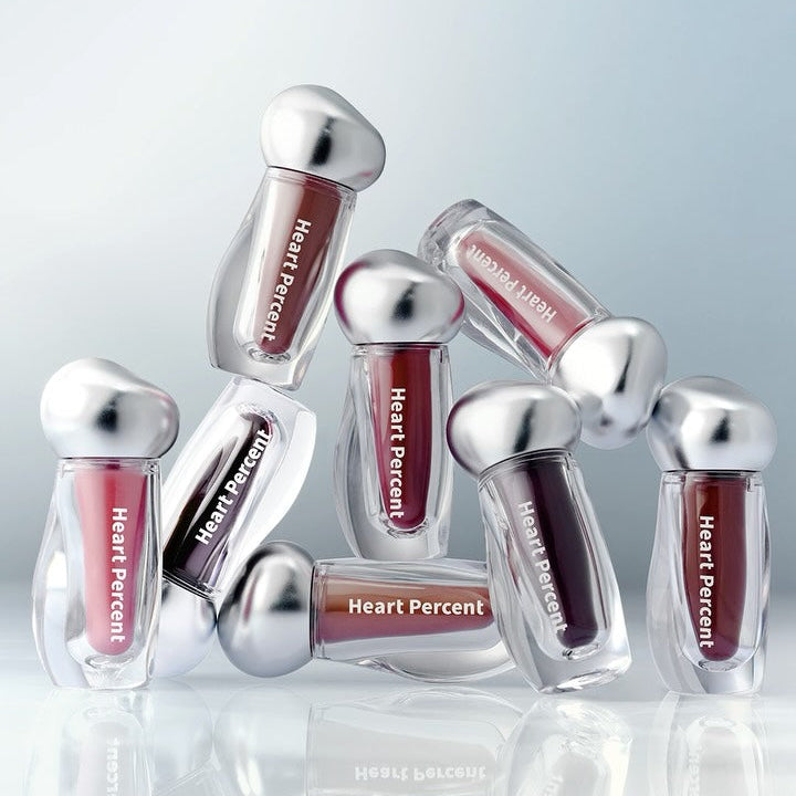 HEART PERCENT Dot On Mood Over Melting Gloss de Heart Percent, packshots brillants sur fond bleu, rendu gloss