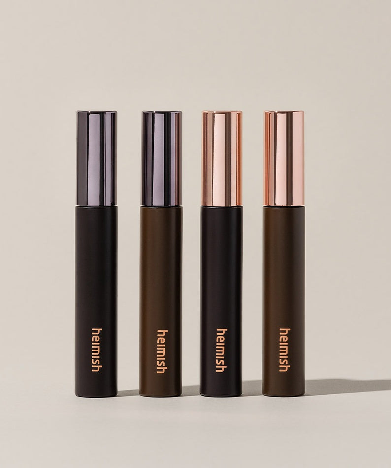 Quatre tubes de HEIMISH Dailism Mascara posés verticalement sur un fond beige.