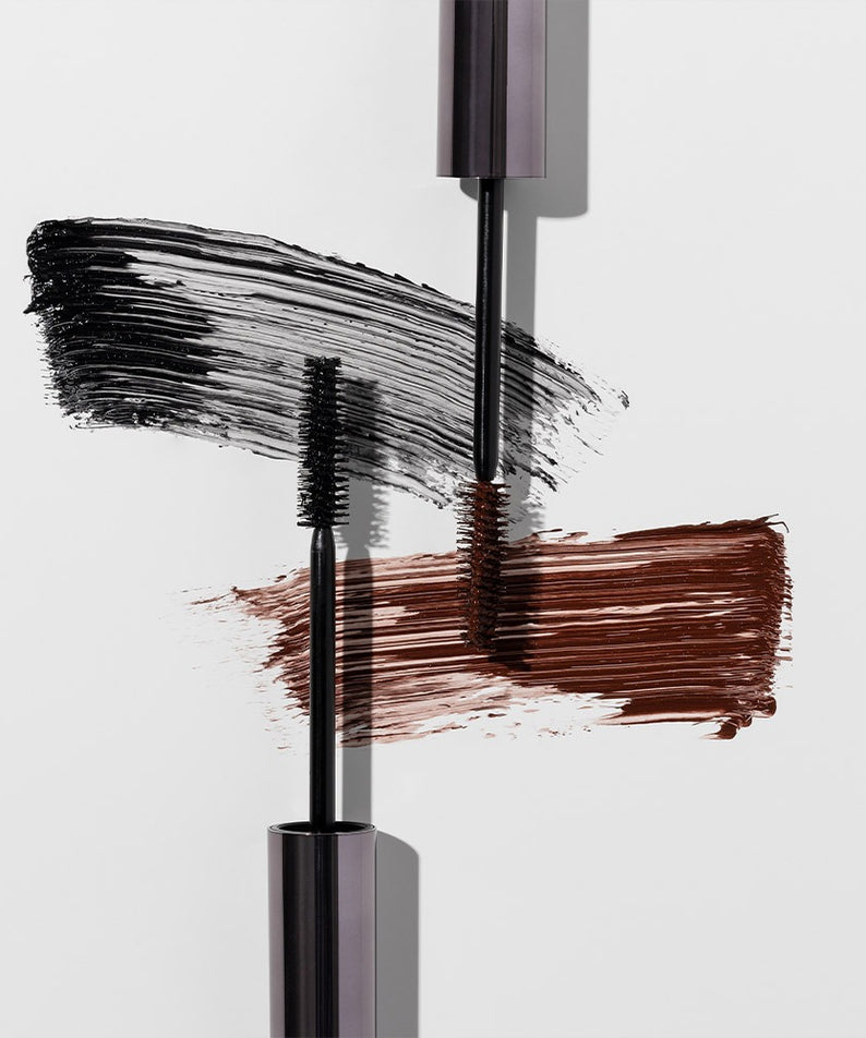 HEIMISH Dailism Mascara en noir et marron avec brosses applicatrices et texture visible sur fond blanc.