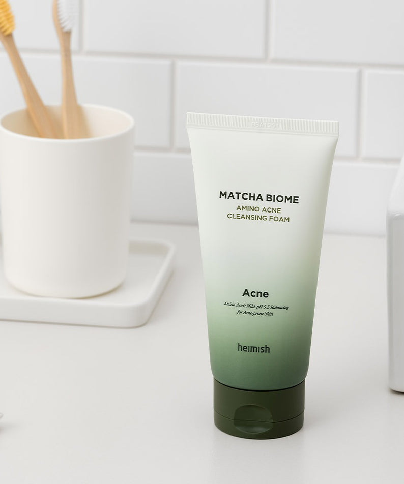 HEIMISH Matcha Biome Amino Acne Cleansing Foam 150g sur un comptoir de salle de bain moderne, nettoyant anti-acné efficace.