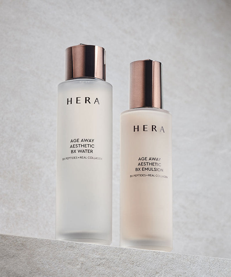 Décris l'image en français : HERA  Age Away Aesthetic BX Water 150ml, deux flacons HERA sur fond clair élégant, contexte studio.