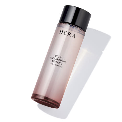 HERA  Comfy Conditioning Essence 150g de HERA, flacon crème beige sur fond blanc, contexte beauté maquillage français.