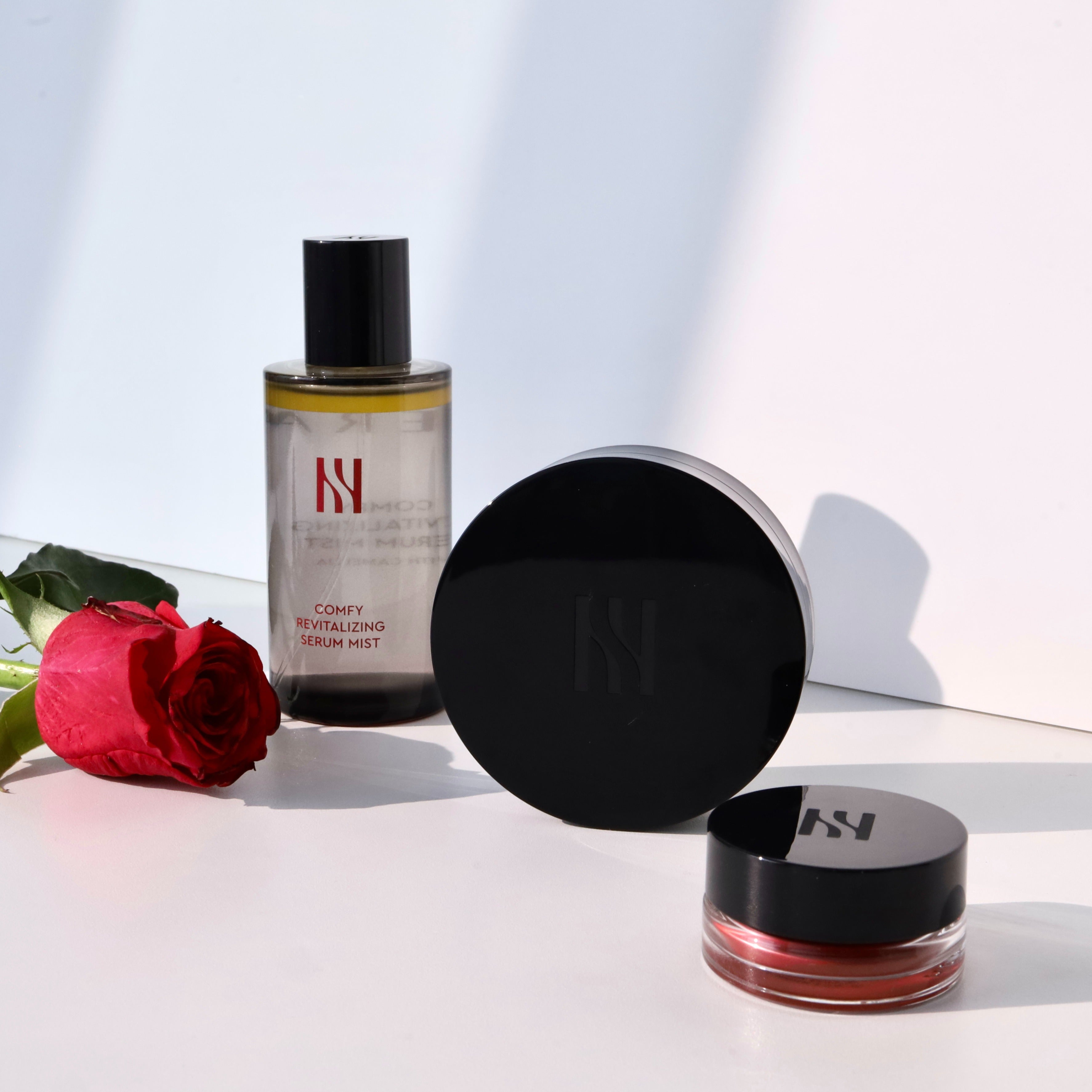 HERA Comfy Revitalizing Serum Mist 90ml de HERA, flacon sur fond clair avec rose rouge et lumière douce