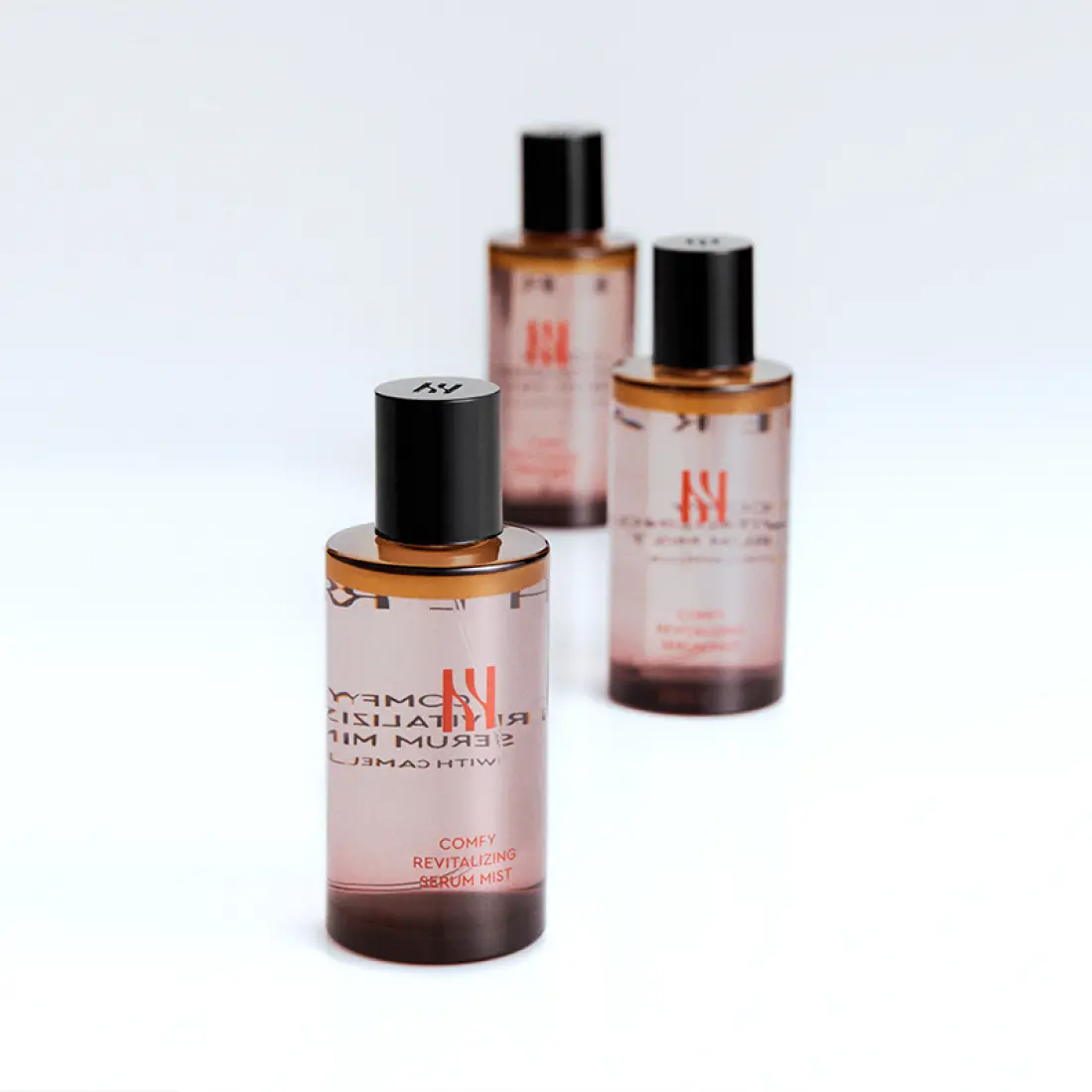 HERA Comfy Revitalizing Serum Mist 90ml de HERA, flacons bruns sur fond blanc, ambiance skincare premium.