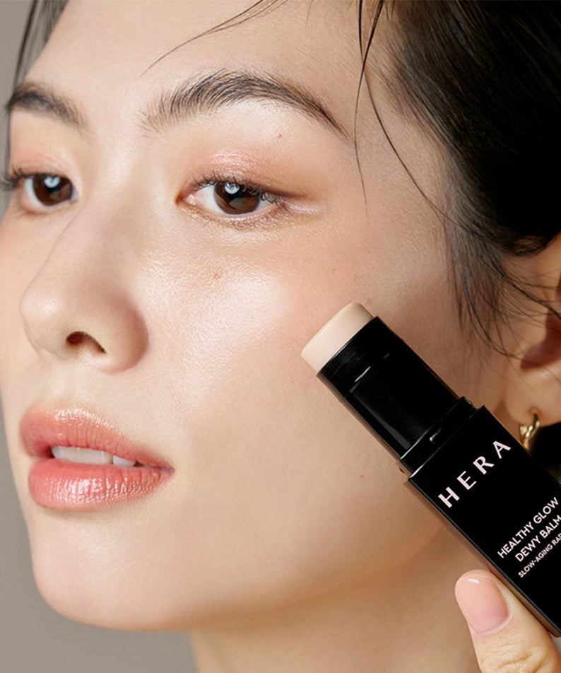 Application du HERA Healthy Glow Dewy Balm 10g sur le visage pour un éclat naturel et lumineux.