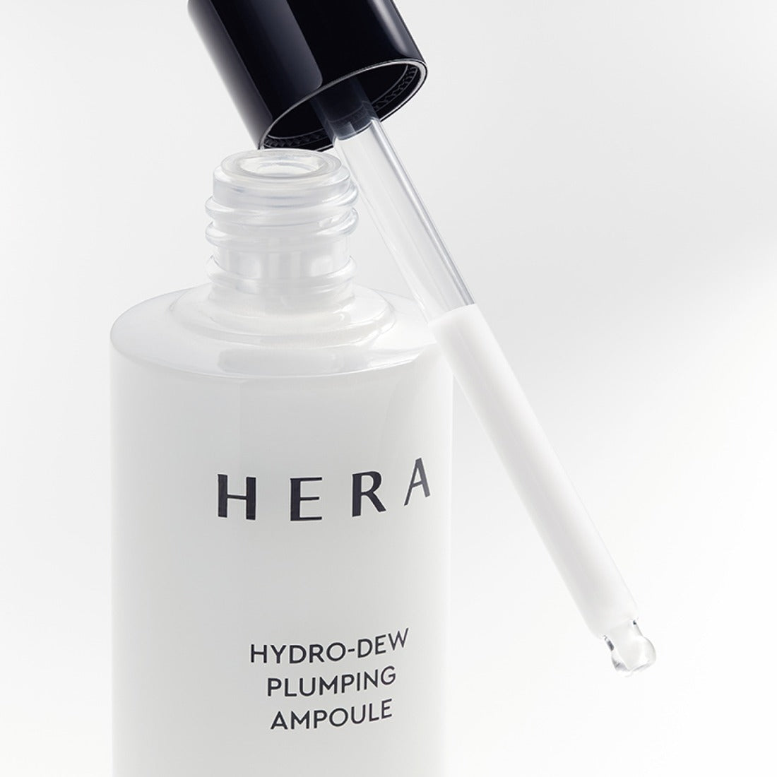 HERA Hydro-Dew Plumping Ampoule 50ml de HERA, flacon blanc et pipette sur fond clair.