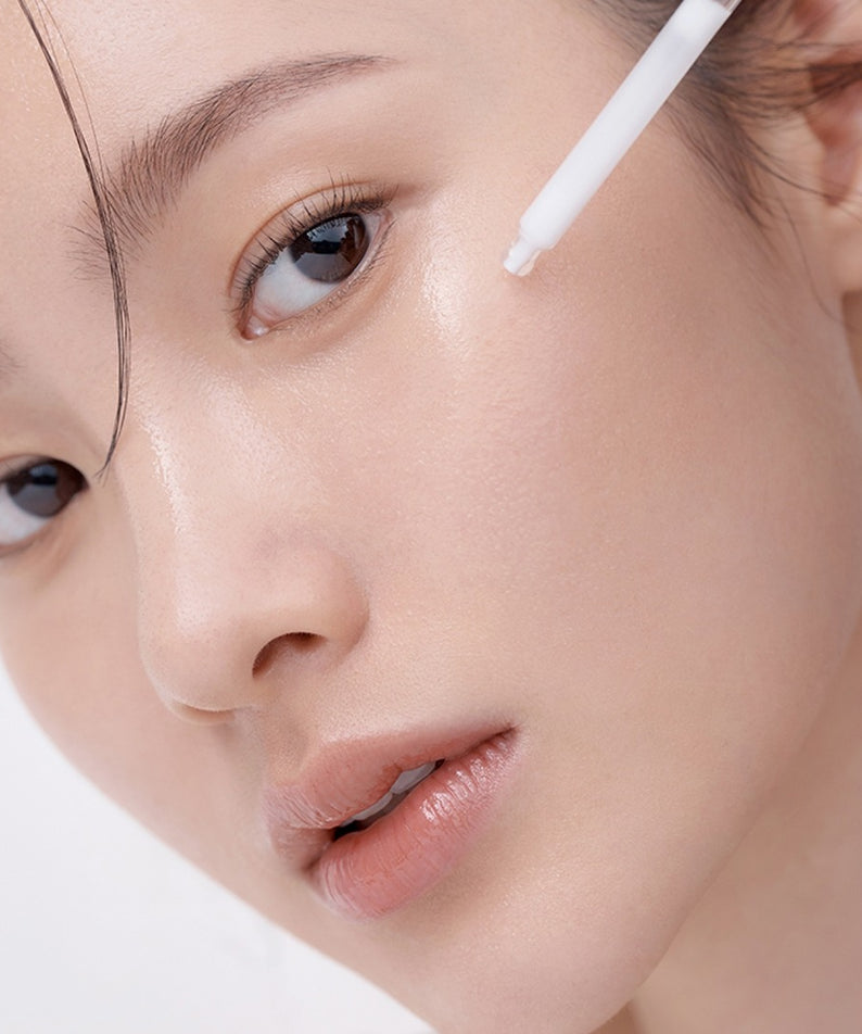 HERA Hydro-Dew Plumping Ampoule 50ml de HERA, sérum hydratant sur le visage, application avec un applicateur, gros plan beauté