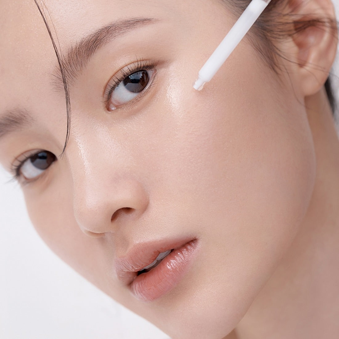 HERA Hydro-Dew Plumping Ampoule 50ml de HERA, sérum hydratant sur le visage, application avec un applicateur, gros plan beauté