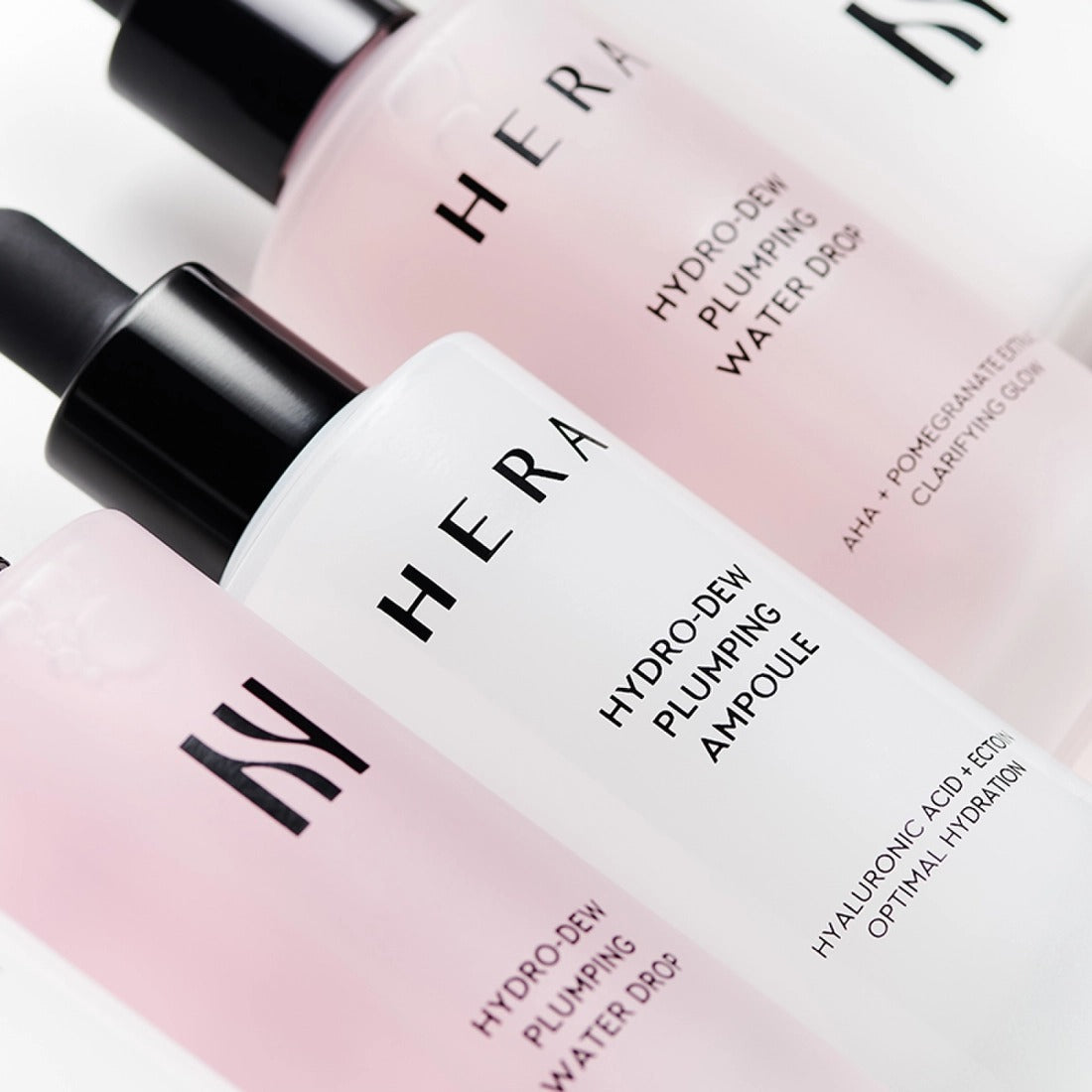 HERA Hydro-Dew Plumping Ampoule 50ml HERA, flacons rose pâle sur fond blanc, vue rapprochée en contexte beauté