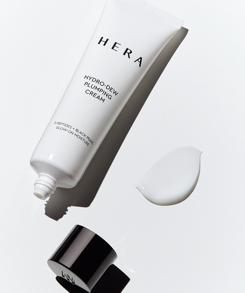 HERA Hydro-Dew Plumping Cream 50ml, crème hydratante HERA en tube blanc sur fond clair, texture et pot échantillon