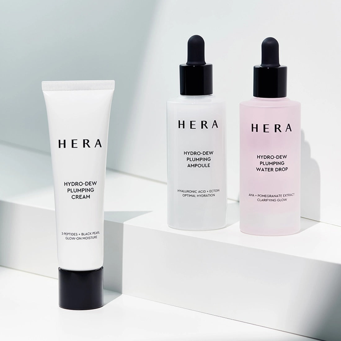 HERA Hydro-Dew Plumping Cream 50ml HERA, tube et flacons sur fond clair, produits cosmétiques pour hydratation.