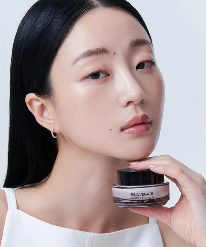 HERA Rejuvanate Ampoule Cream 50ml, pot noir sur fond clair, femme maquillée posant avec la crème HERA