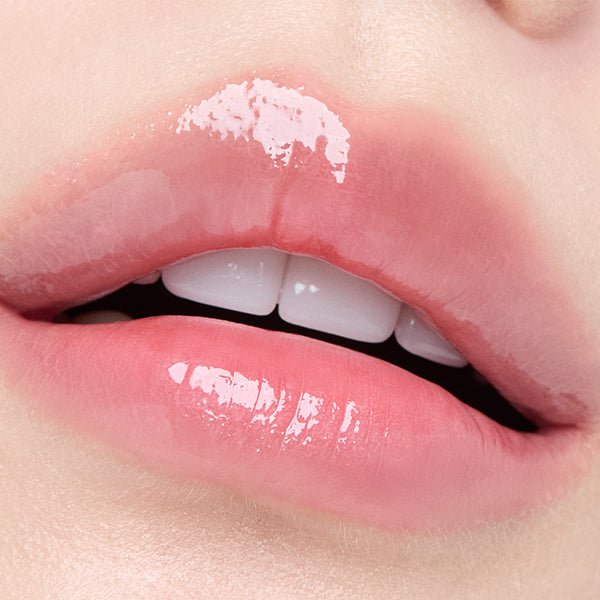 Gros plan sur lèvres brillantes avec HERA Sensual Tinted Shine Lip Serum 8.5g, teinte rosée HERA, contexte cosmétique