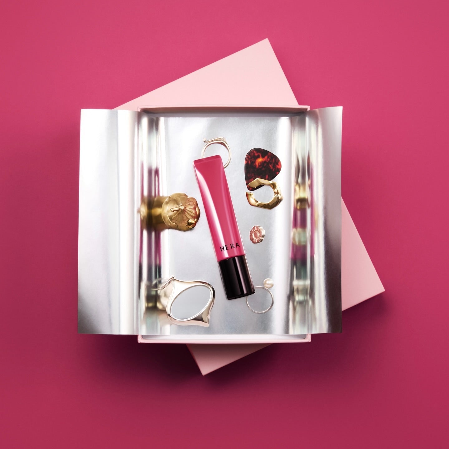 HERA Sensual Tinted Shine Lip Serum 8.5g, en packaging élégant sur fond rose, produit HERA en vue produit.