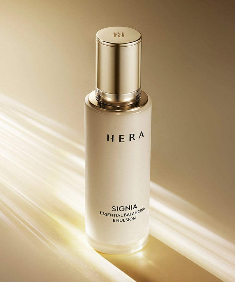 HERA Signa Essentail Balancing Emulsion 150ml de HERA, flacon doré sur fond beige avec lumière et lignes.