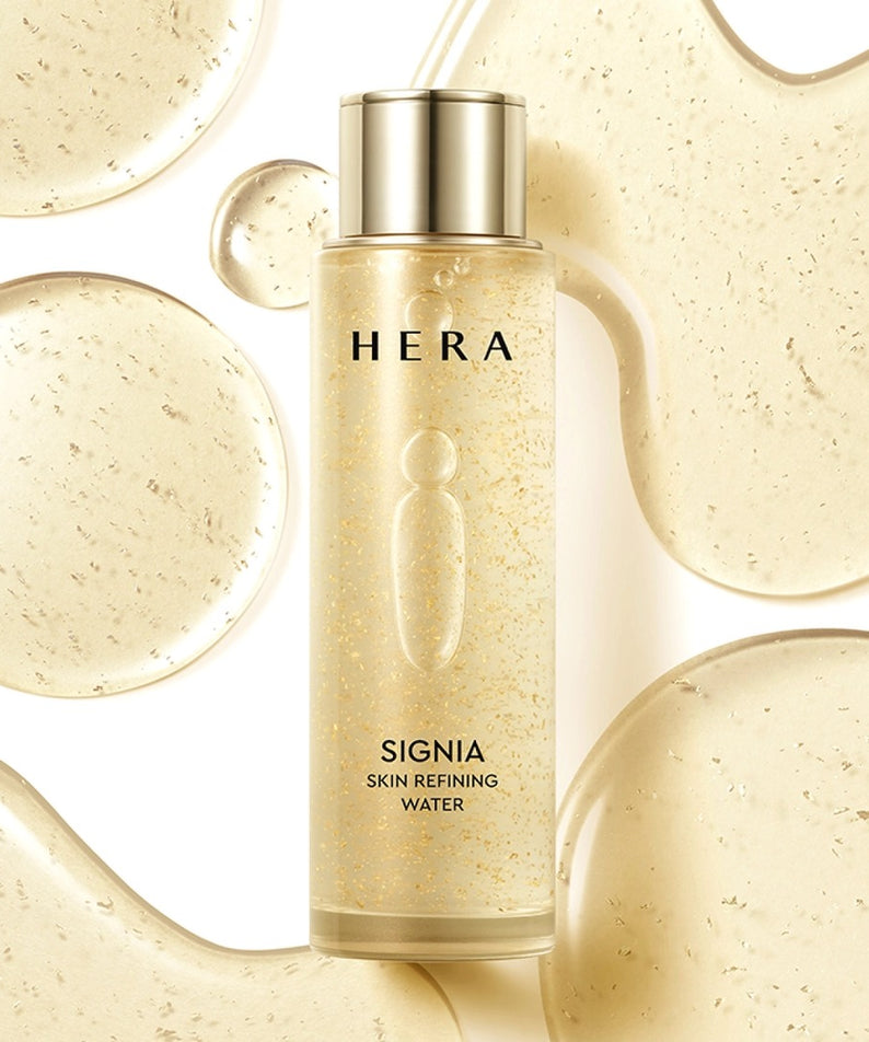 HERA Signa Skin refreshing Water 180ml de HERA, flacon doré sur fond beige, gouttes et éclats visuels