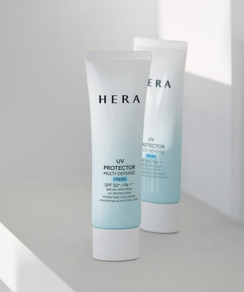 HERA UV Protector Multi-Defense Fresh SPF50+PA++++ 50ml, tubes crème solaire HERA en décor lumineux, fond clair, intérieur.