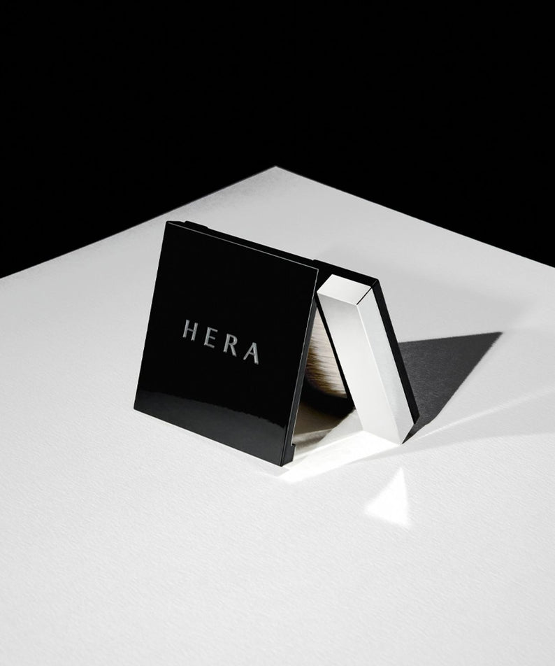 Palette de maquillage HERA Airy Powder Primer 8.5g en noir élégant, posé sur une surface blanche, mettant en valeur le design compact.