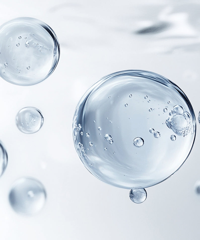 HERA Homme Blue Essence In Toner 125ml avec bulles hydratantes sur fond transparent, capture du produit de soin pour homme.