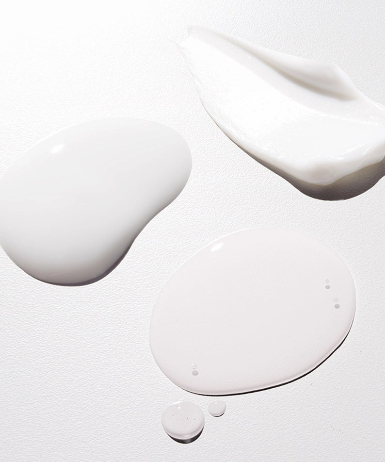 Textures de HERA Hydro-Dew Plumping Ampoule 50ml sur une surface blanche. Hydratation intense et éclat pour la peau.