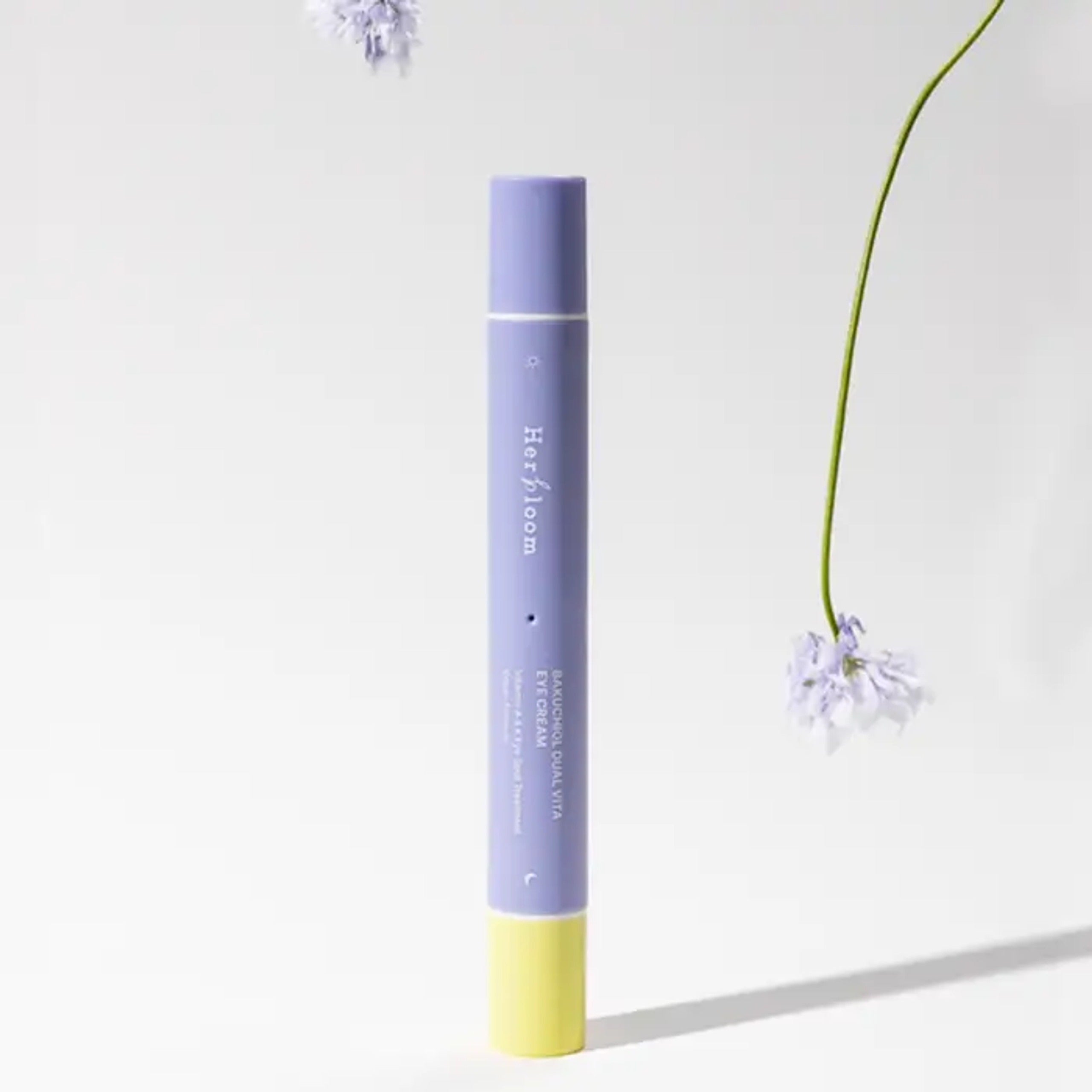 HERBLOOM  Bakuchiol Dual Vita Eye Cream : flacon bleu et jaune sur fond clair, fleurs délicates en décor visuel