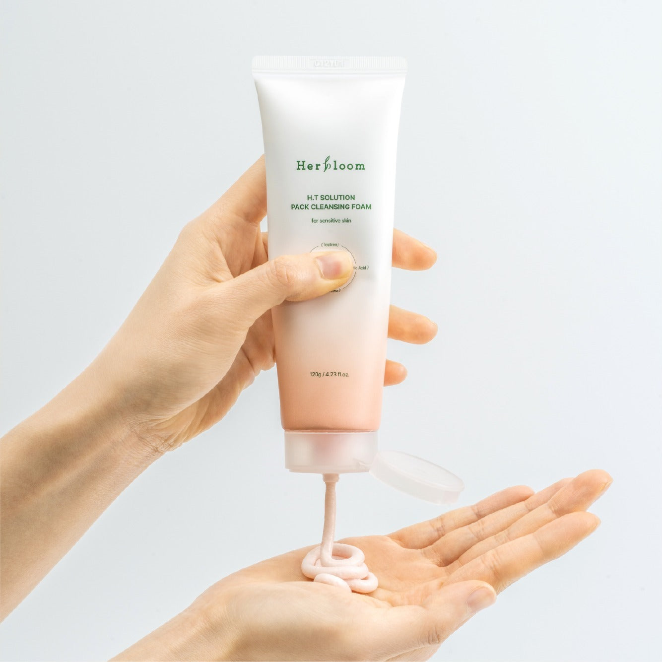 HERBLOOM  H.T Solution Pack Cleansing Foam 120g : tube nettoyant tenu en main, mousse sur mains, fond clair.