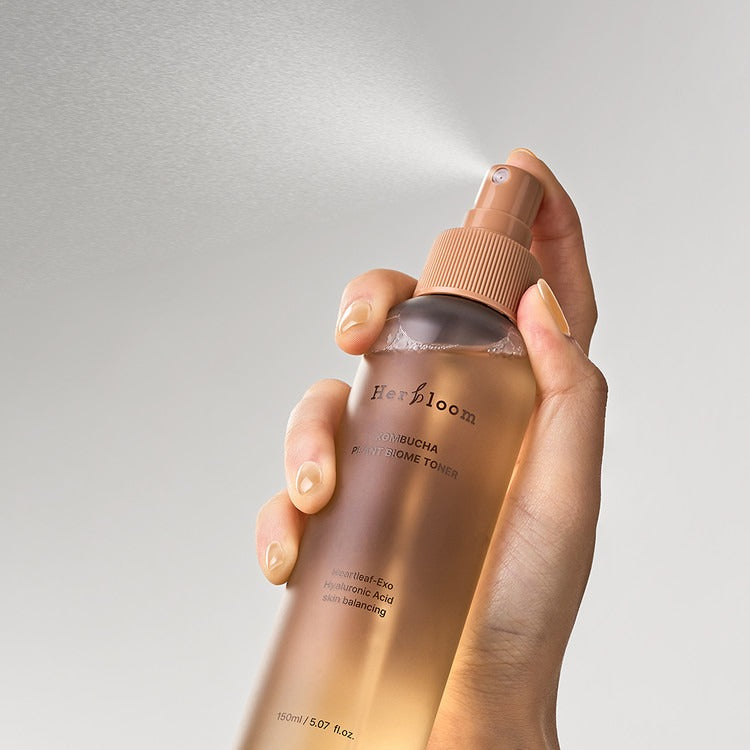 HERBLOOM  Kombucha Plant Biome Toner 150g : vaporisateur sur fond clair, main tenant le produit de la marque Herbloom.