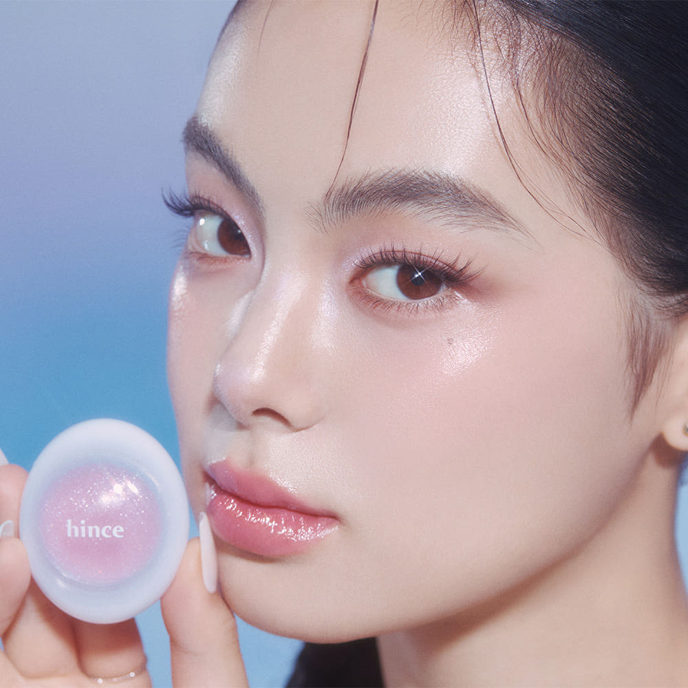 Portrait maquillage éclatant avec HINCE Low Glow Dewy Ball (Lip & Cheek) sur les lèvres, teinte rosée, fond bleu