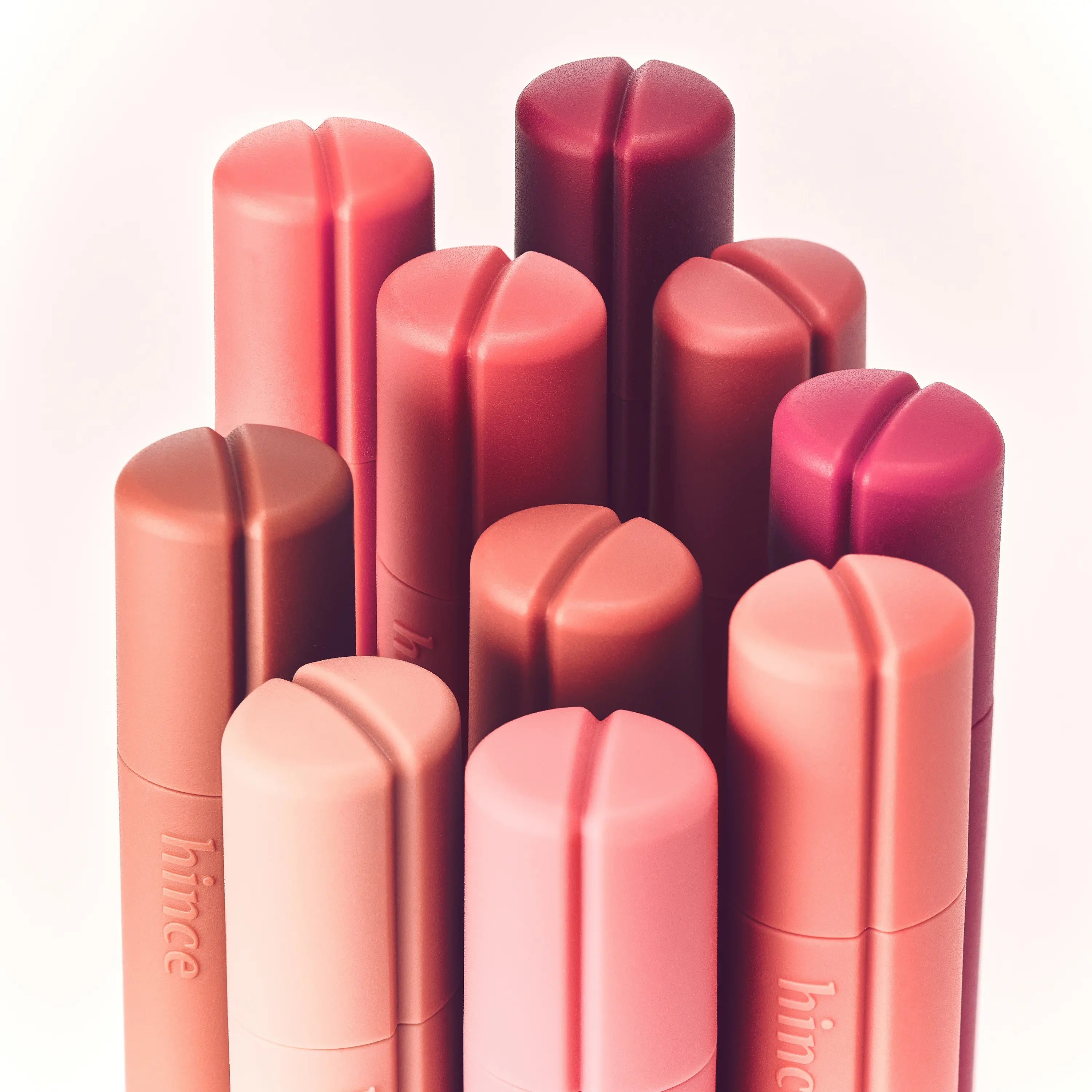 HINCE Nouvelle Tint 10 Colors, baumes à lèvres HINCE rose et rouge sur fond clair, packshot produits.