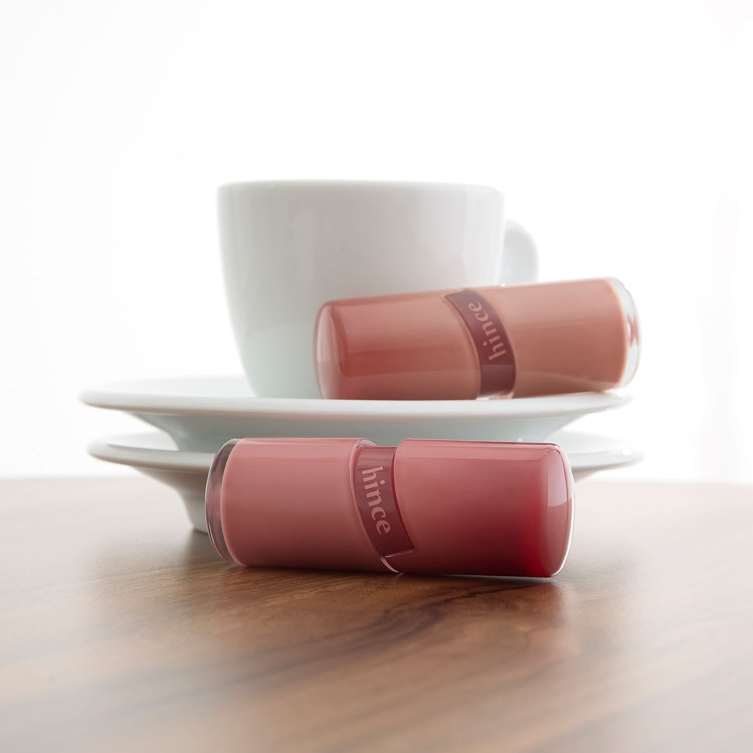 HINCE  Raw Glow Gel Tint, tube rose sur fond clair avec tasse, gel teint low glow de la marque HINCE