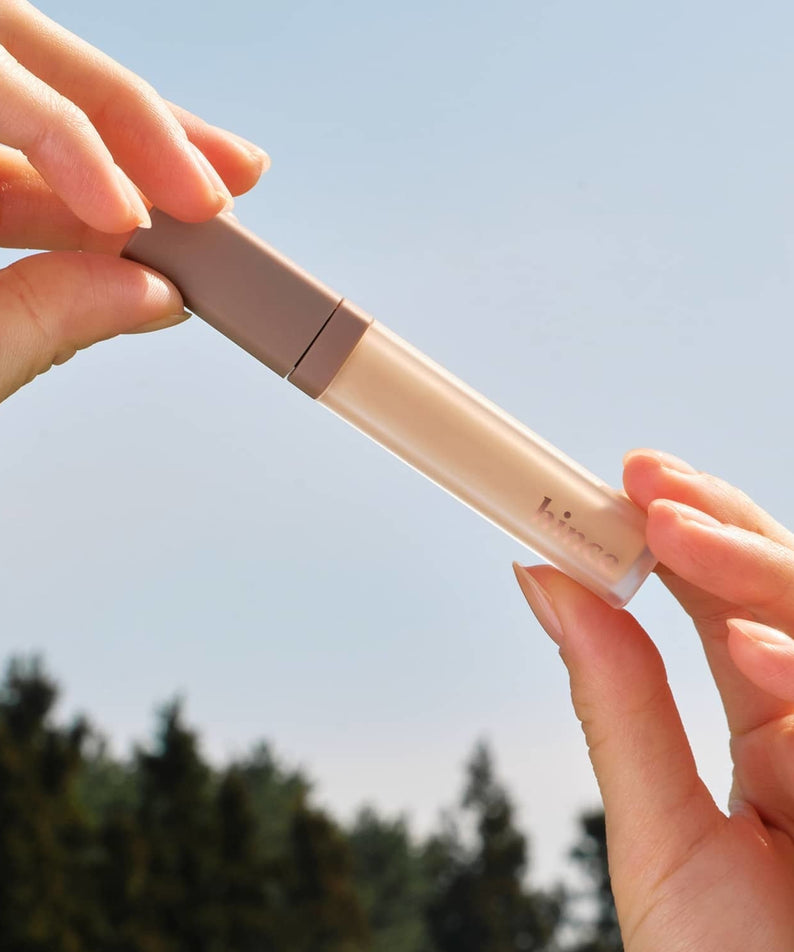 HINCE Second Skin Cover Concealer en plein air, montrant sa texture légère et naturelle sous la lumière du jour.
