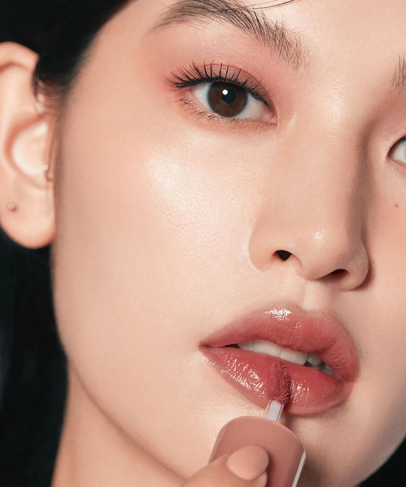 Application délicate du HINCE Low Glow Gel Tint sur les lèvres, donnant un éclat doux et lumineux. Teinte gel élégante pour un look raffiné.