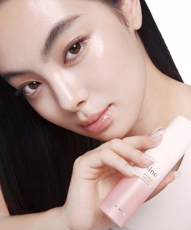 Femme tenant HINCE Radiance Makeup Boosting Prep 30ml, produit pour un éclat naturel et préparation du maquillage.