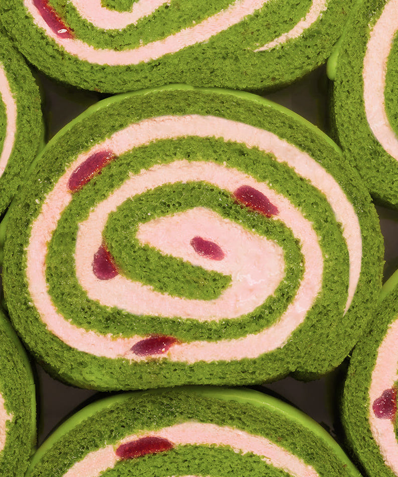 HIT THE TEA Super Matcha Strawberry Rool Cake Gluten-Free : tranches en spirales vert matcha et rose, fond chocolat noir.