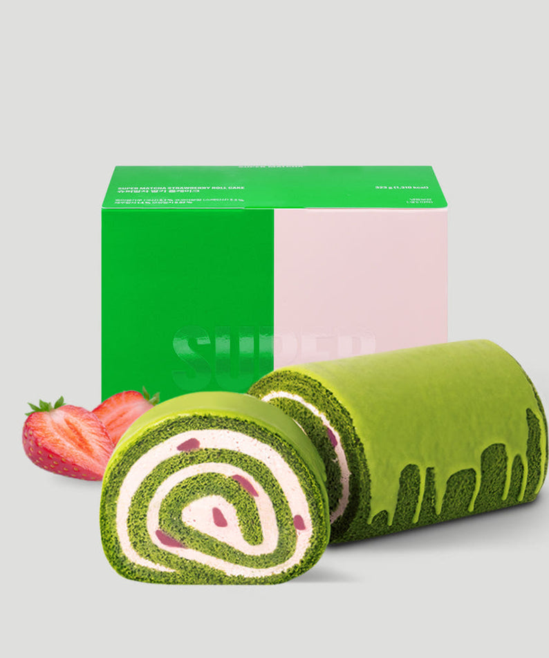 HIT THE TEA Super Matcha Strawberry Rool Cake Gluten-Free avec boîte d'emballage verte et fraises fraîches en arrière-plan.