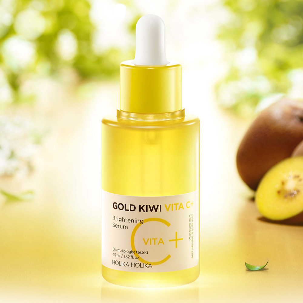 Décris l'image en français: HOLIKA HOLIKA Gold Kiwi Vita C+ Brightening Serum 45ml, flacon jaune, kiwi et soleil en arrière-plan.