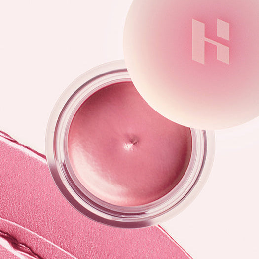 HOLIKA HOLIKA Melting Blur Lip Pot 5g, pot à lèvres rose sur fond maquillage, logo Holika visible, texture gélifiée.