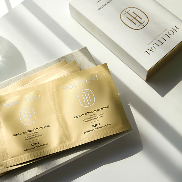 HOLITUAL Radiance Resurfacing Peel de la marque HOLITUAL, sachets sur fond blanc lumineux, produits skincare.
