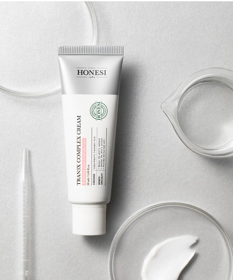 HONESI  Tranex Complex Cream 50ml, tube crème sur fond blanc minimal, flacon et texture de crème, photo produit