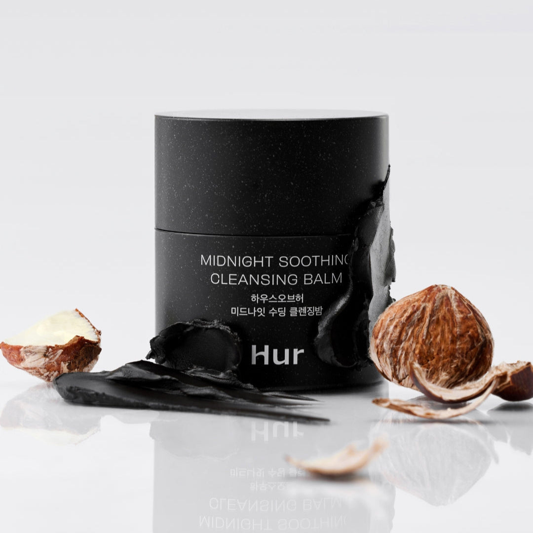 HOUSE OF HUR Midnight Soothing Cleansing Balm : pot noir sur fond clair, noisettes et noix autour, ambiance spa nocturne